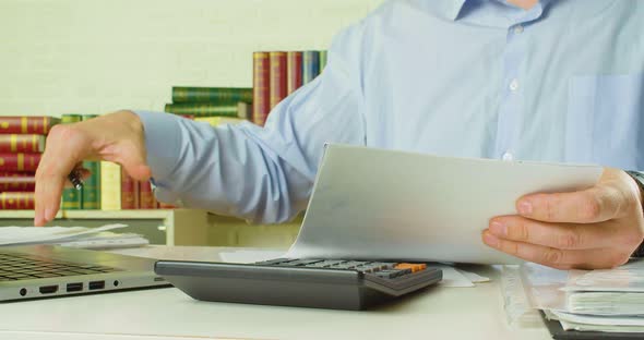 Male Hands with Documents  a Man at the Workplace in the Office Checks Documents