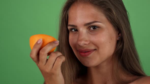 Happy Beautiful Woman Smiling Joyfully, Holding an Orange