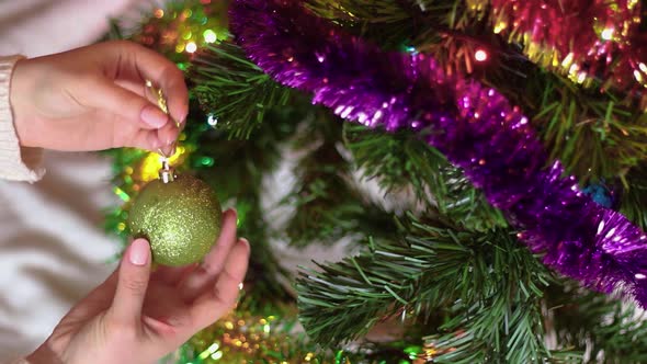 Woman decorates Christmas tree.