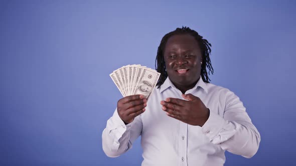 African Man Holding Money in His Hand and Pointing on It with the Other