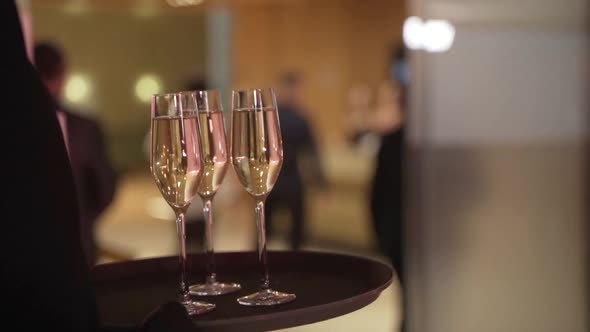 Closeup of Champagne on the Tray Waiter Keep the Tray with a Glasses of Champagne