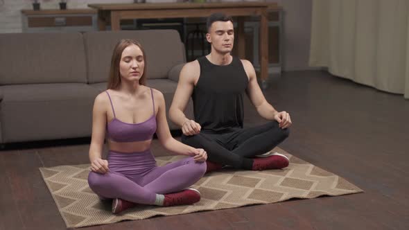 Top View Of Young Happy Caucasian Man And Woman Couple In Sportswear Doing Stretching yoga