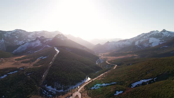 Aerial shot of breathtaking mointain range under a bright shining white sky in León, Spain. Green fo