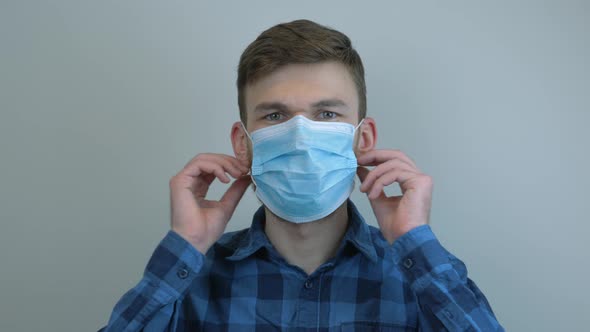 Man takes off protective medical mask and hard breathing after quarantine. Pandemic concept