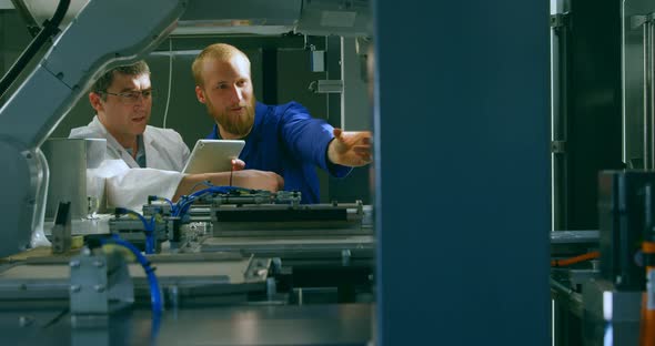 Robotic engineers checking machinery in warehouse 4k