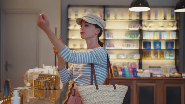 Beautiful girl choosing a perfume in Paris