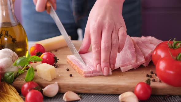 Making Pasta Carbonara Slicing Traditional Pancetta Bacon Into Pieces on a Wooden Cutting Board with