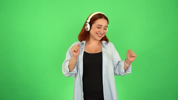 Woman Listening to Music with Headphones on Green Screen 4K