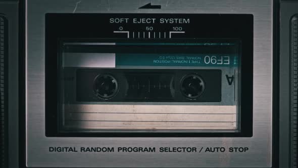 Audio Cassette Rotates in Deck of an Old Tape Recorder