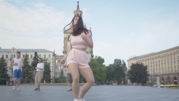 Confident Female Dancer Spinning in Modern Dance on City Square. Portrait of Beautiful Brunette