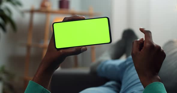 Man Scrolling Smartphone Mock Up Screen While Holding It in Horizontal Landscape Mode. Guy Watching