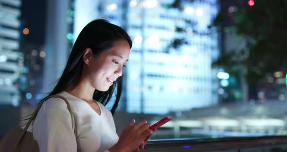 Woman use of mobile phone in city at night