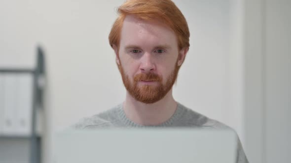 Beard Redhead Man with Laptop Smiling at Camera