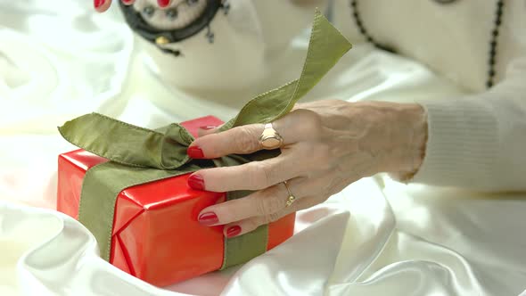 Woman Hands Untied Bow on Gift Box.