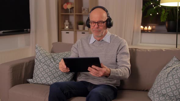 Senior Man with Tablet Pc and Headphones at Home