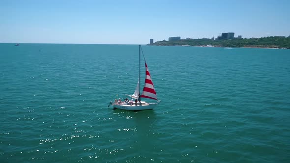 Sailboat cruise at serene seascape. Yacht sailing in open sea at windy day, aerial view