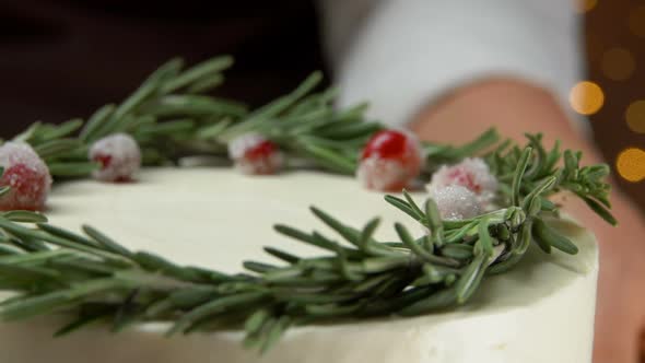 Closeup of Delicious Christmas Cream Cake with Rosemary Wreath and Cranberries