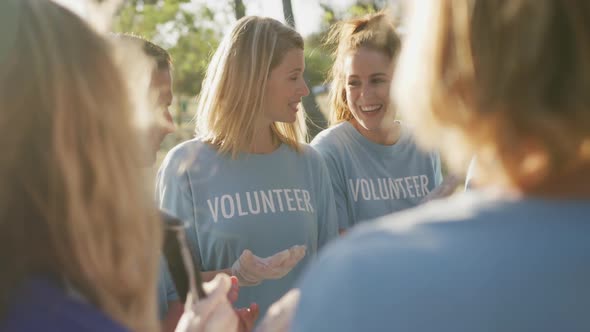 Mid adults volunteering and clapping hands during river clean-up day