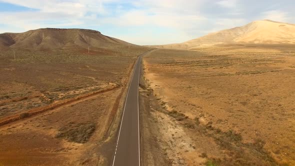 Aerial view of an empty road in dryland of Fuerteventura.