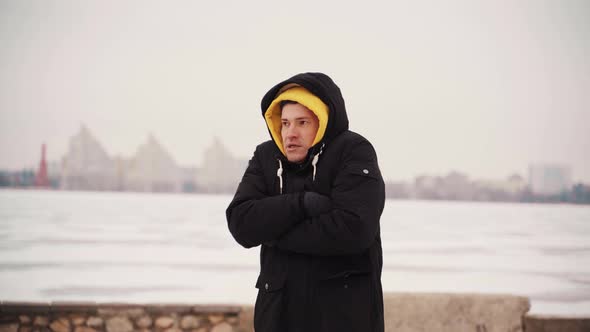 Young Frozen Man in Black Jacket Jumps From Cold Standing on Street