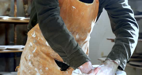 Male potter washing hands 