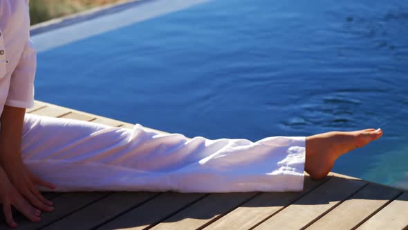 Senior woman doing stretching exercise near poolside 4k