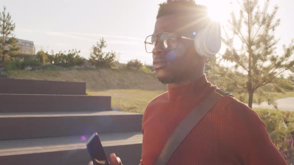 Young Black Man Enjoying Music in Headphones Outdoors