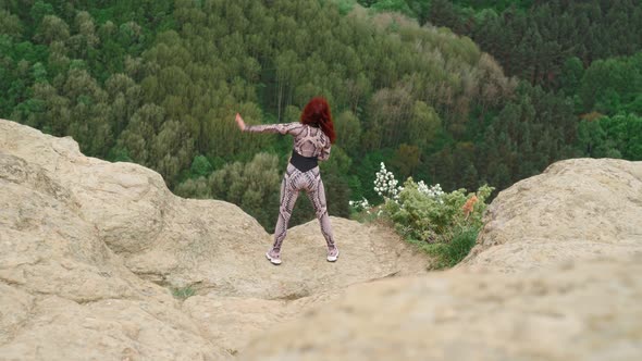 Athletic Woman Practices Yoga on Top Mountain