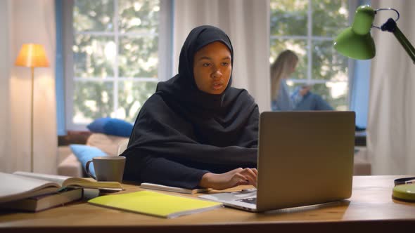 Islamic Young Woman Student Wearing Abaya and Typing on Laptop in College Common Room