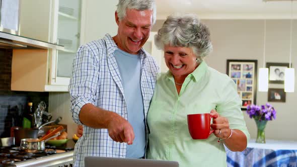 Senior couple using laptop while having coffee 4k