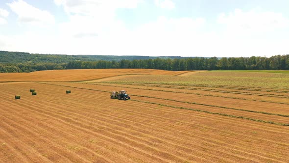 Aerial view on the field and tractor working on the natural rural background.
