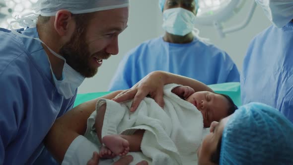 Close-up of Caucasian couple looking at their newborn baby in hospital