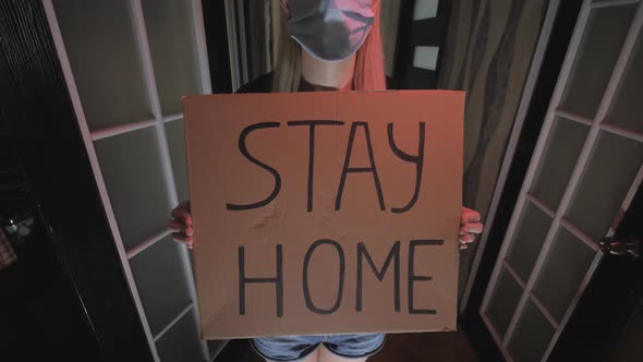 Woman with a message written on cardboard, stay home, quarantine, coronavirus.