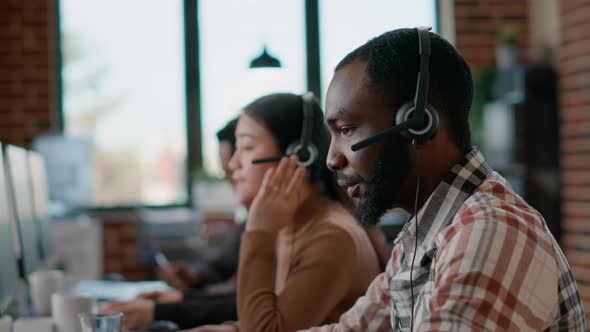 Male Worker Answering Telework Phone at Call Center