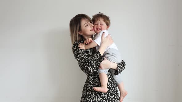 Mother with son on white wall background in home