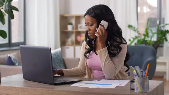 Woman with Laptop Calling on Phone at Home Office