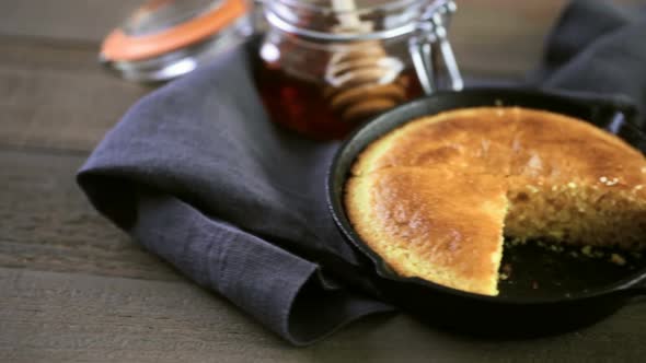 Slice of sweet cornbread with honey on the plate