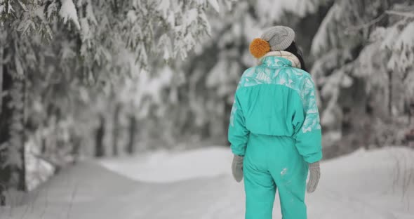 Woman in Ski Suit in Snowy Forest During Winter Vacations Outdoors