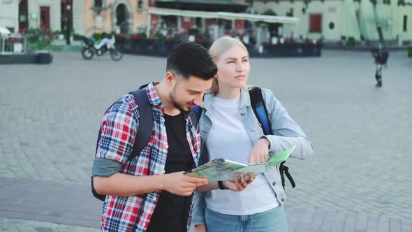 Tourists Couple Holding Map for Finding New Interesting Place for Sightseeing