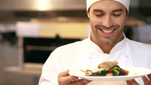 Handsome chef smelling dish and doing ok sign