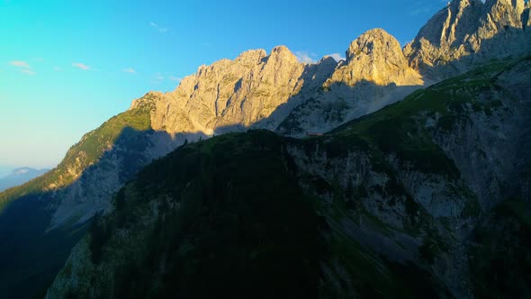 Aerial view across majestic shadow slopes of sunlit Wilder Kaiser mountains elevation