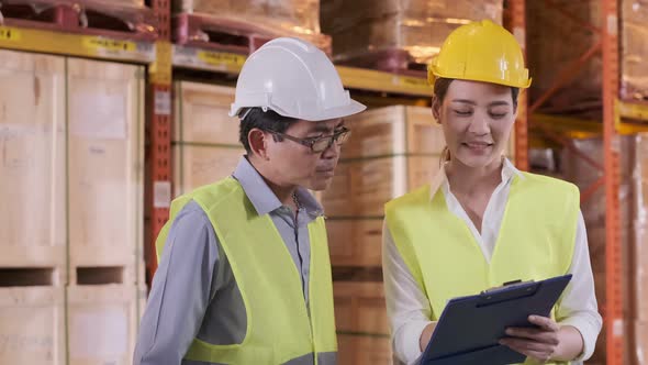 asian Male and Female Industrial Engineers in Hard Hats