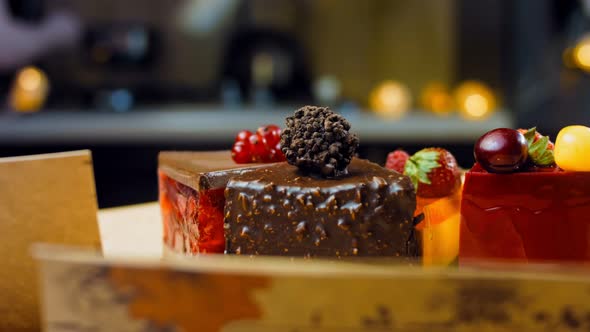 A Few Slices of White and Red Strawberry and Cherry Cake and Chocolate in an Open Box