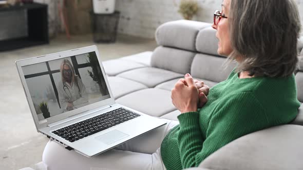 Mature Senior Woman is Using a Laptop at Home