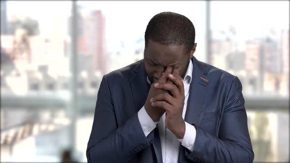 Afro-american Businessman Is Crying on Blurred Background.