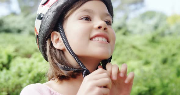 Smiling girl wearing helmet in the park