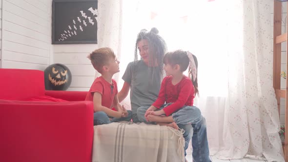 Children with Their Mother Decorate the Room for Halloween