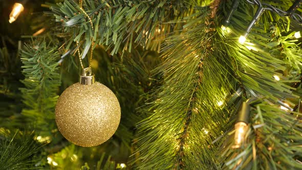 Gold color bauble on the Christmas  tree branch 4K 2160p 30fps UltraHD footage - Golden round orname