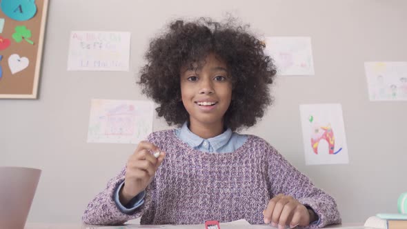 Happy African Kid Girl Looking at Web Cam Talking Remote Learning Online