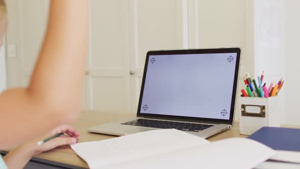 Caucasian girl having a video call on laptop with copy space while doing homework at home